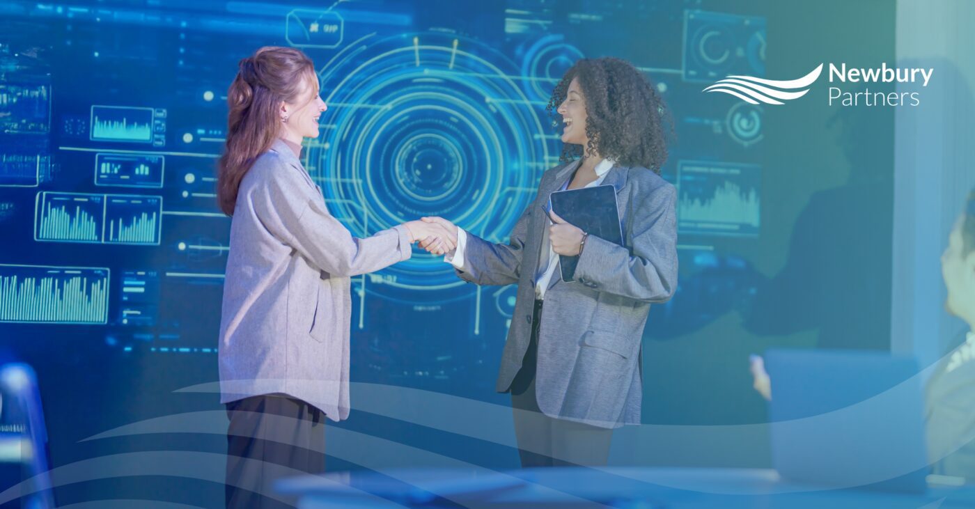 Two staffing professionals shaking hands in front of a data dashboard, representing how commissions visibility drives recruiter motivation and performance.