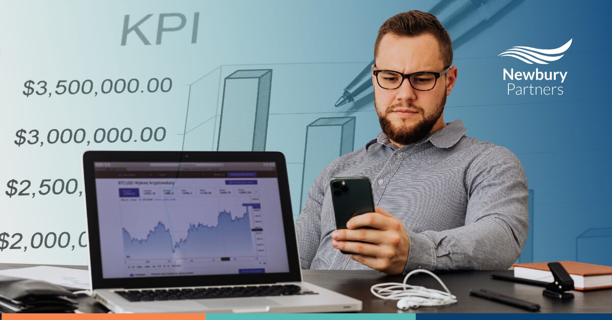 Business professional analyzing KPI metrics and tech adoption data on laptop and mobile device displays.