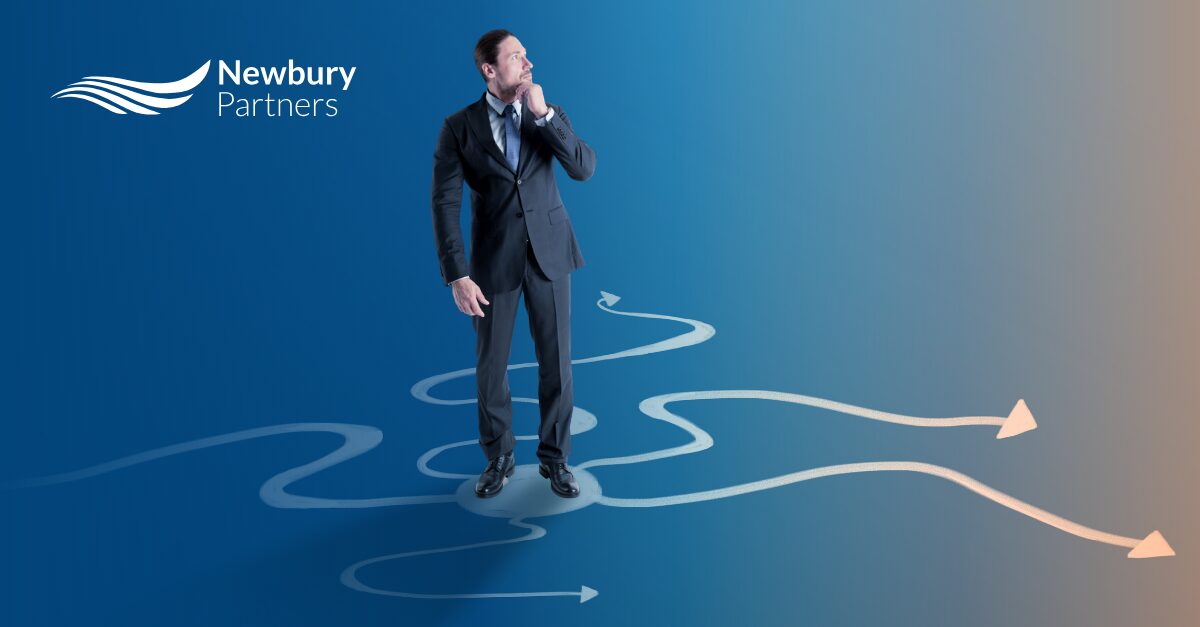 A professional in a suit standing at a crossroads of diverging arrows, reflecting the decision between Bullhorn vs bespoke commissions.